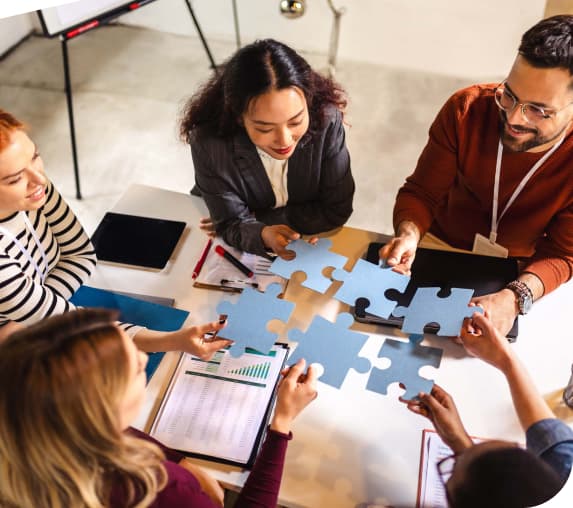Partner:innen fügen Puzzlestücke zusammen – Symbol für Zusammenarbeit und gemeinsame Finanzberatung.