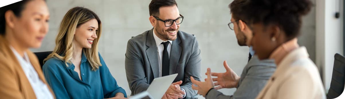 Team von Finanzberater:innen im Gespräch – symbolisiert Partnerschaft und persönliche Vermögensberatung.